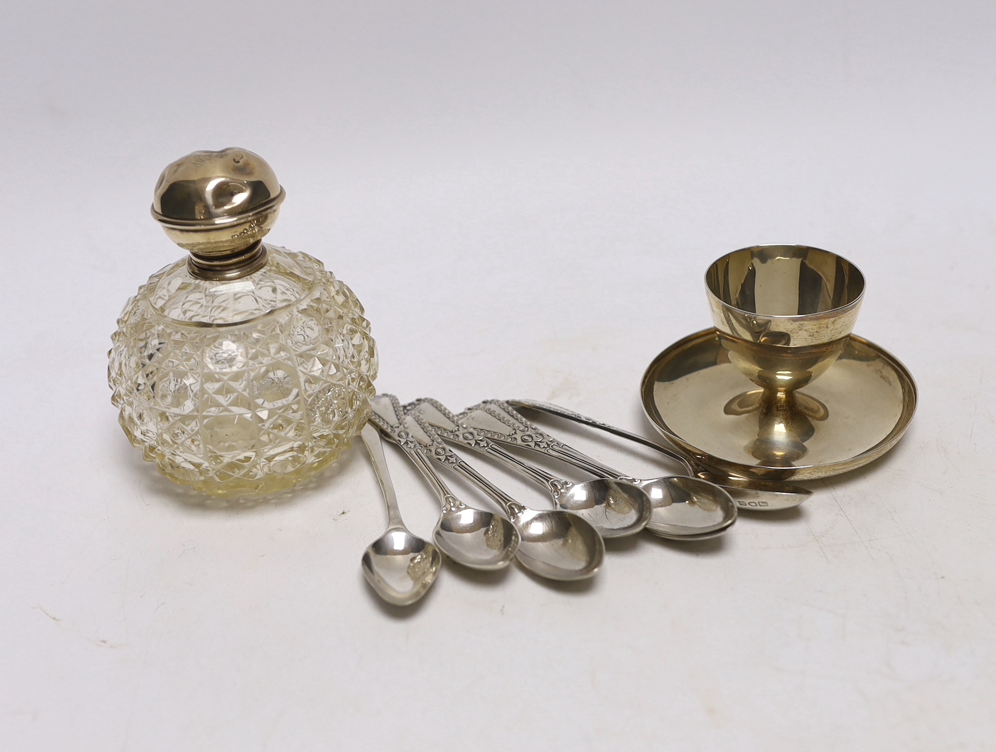 A set of six George V silver coffee spoons, Goldsmiths & Silversmiths Co Ltd, London, 1910, a similar silver Old English pattern coffee spoon, a silver egg cup and silver mounted glass toilet jar.